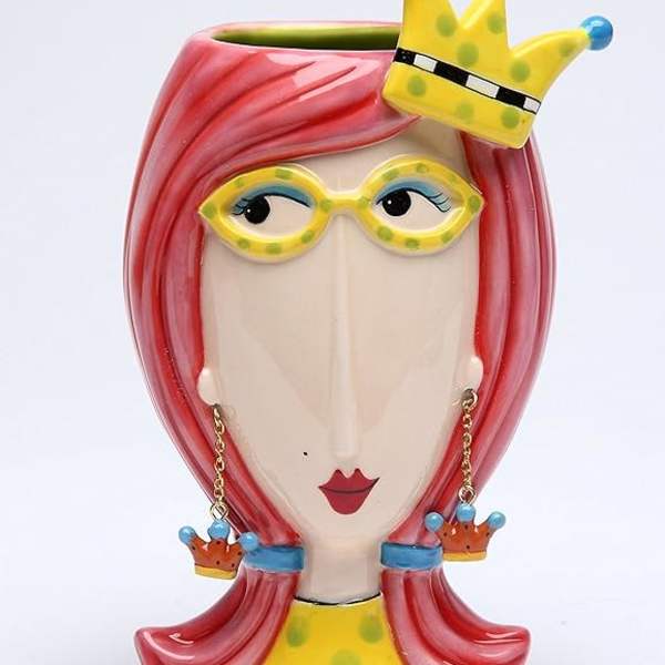 Decorative ceramic face vase with pink hair and a crown