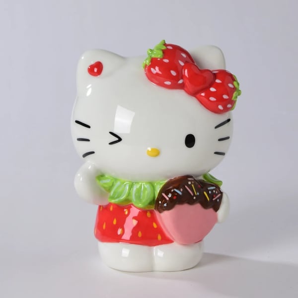 Hello Kitty figurine holding a chocolate-dipped strawberry