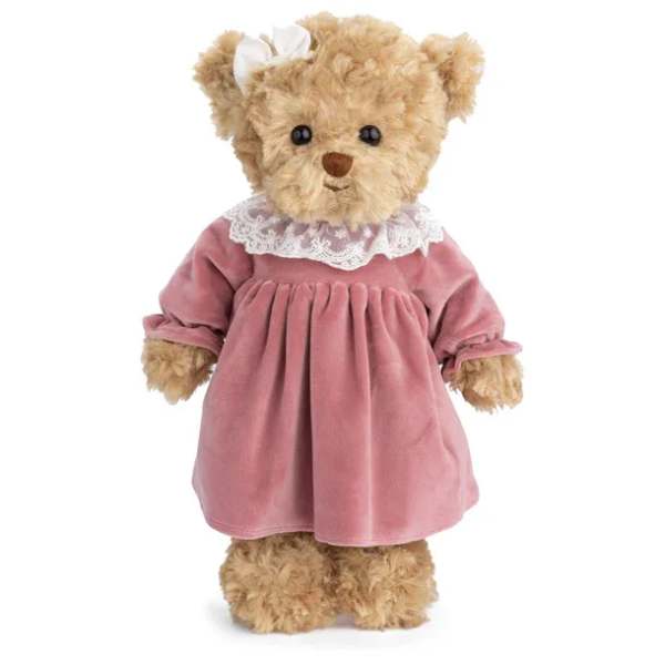 Brown teddy bear in a pink velvet dress with white lace collar and hair bow