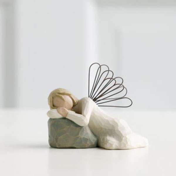 Small angel figurine resting on a stone base