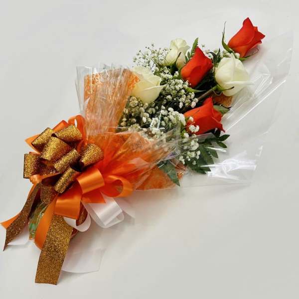 Bouquet of red and white roses wrapped with orange ribbon