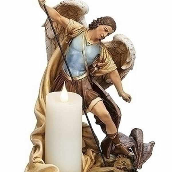 Angel figurine beside a white pillar candle