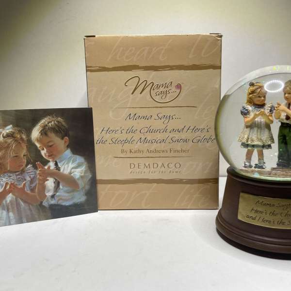 Decorative snow globe with two children figurines and a matching box