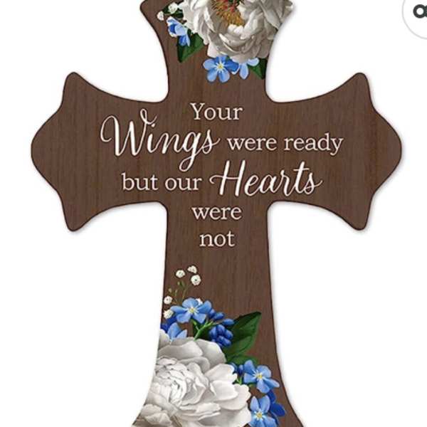 Wooden cross plaque with white and blue flowers and memorial text