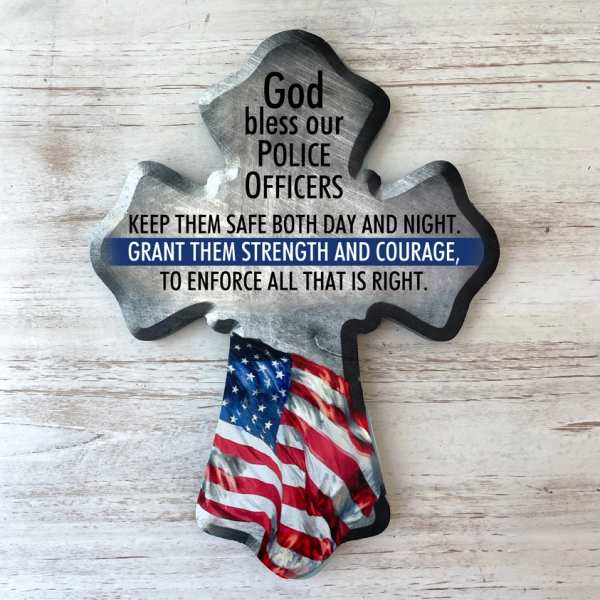 Cross-shaped memorial sign with police tribute text and an American flag design