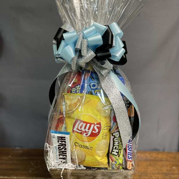 Gift basket wrapped in cellophane with assorted snacks and a large blue and silver bow