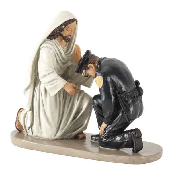 Religious figurine of Jesus blessing a kneeling police officer