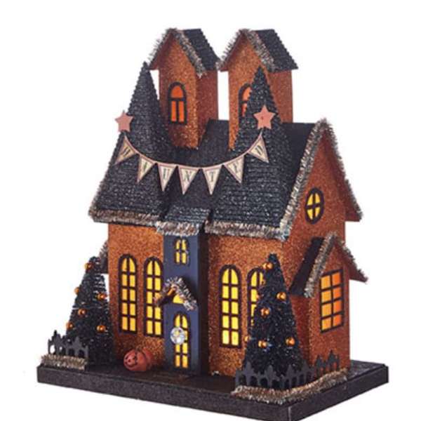 Halloween haunted house decoration with lit windows and small trees