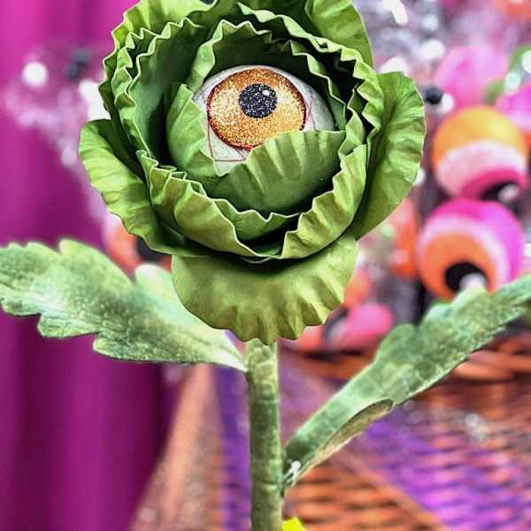 Green paper flower with an eyeball center on a stem