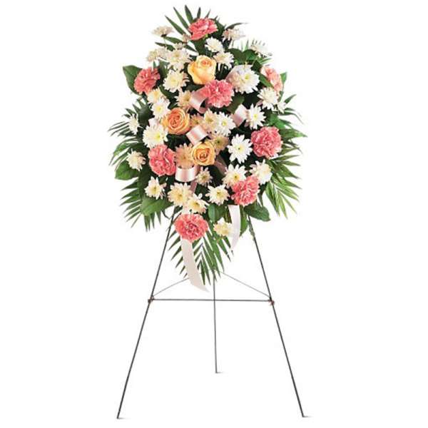 Standing spray with peach roses, pink carnations, and white daisies on a metal easel