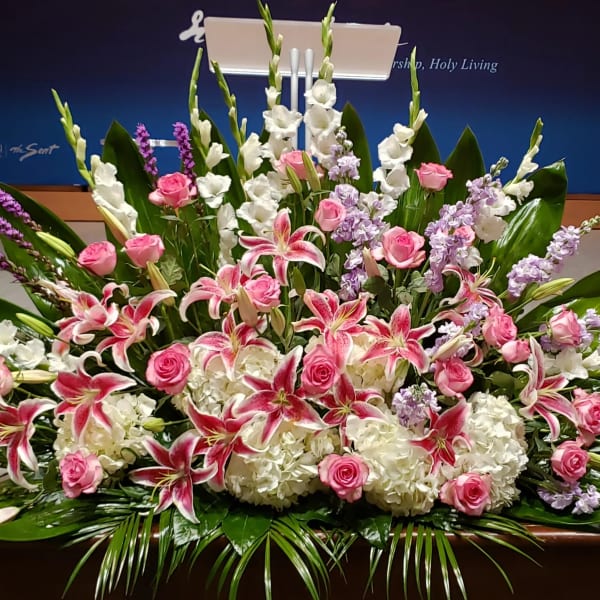 Large pink and white lily and rose arrangement with hydrangeas and lavender flowers in a low spray design