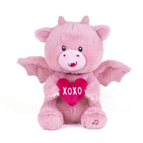 Pink plush dragon holding a red heart with XOXO text