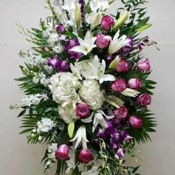 Tall standing floral spray with white lilies, pink roses, and purple orchids