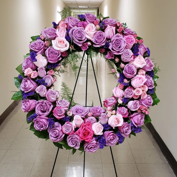 Standing wreath of lavender and pink roses on a black easel