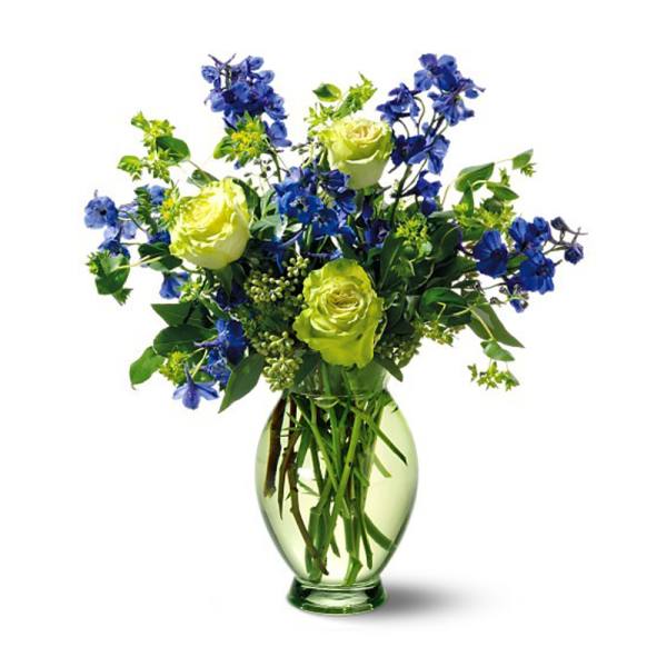 Blue and lime-green flowers arranged in a glass vase