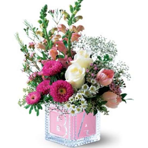 Pink and white floral arrangement in a pink baby block vase