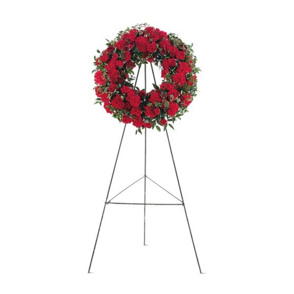 Red carnation wreath displayed on a tall metal easel stand