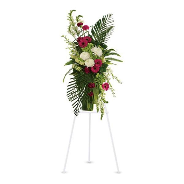 Tall green and white standing arrangement with pink gerbera daisies in a vase on a white tripod stand