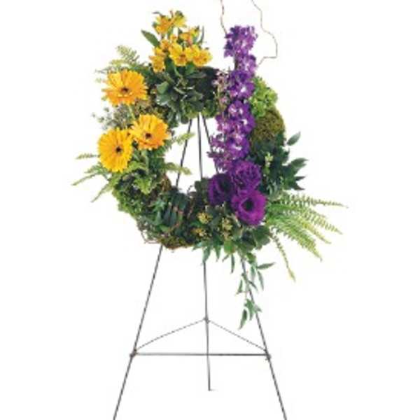 Standing wreath of yellow and purple flowers on a metal easel