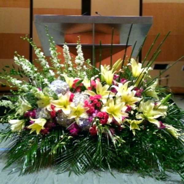 Large floral arrangement with yellow lilies and pink flowers