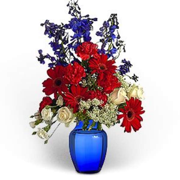 Red and white mixed bouquet in a blue vase with blue filler flowers