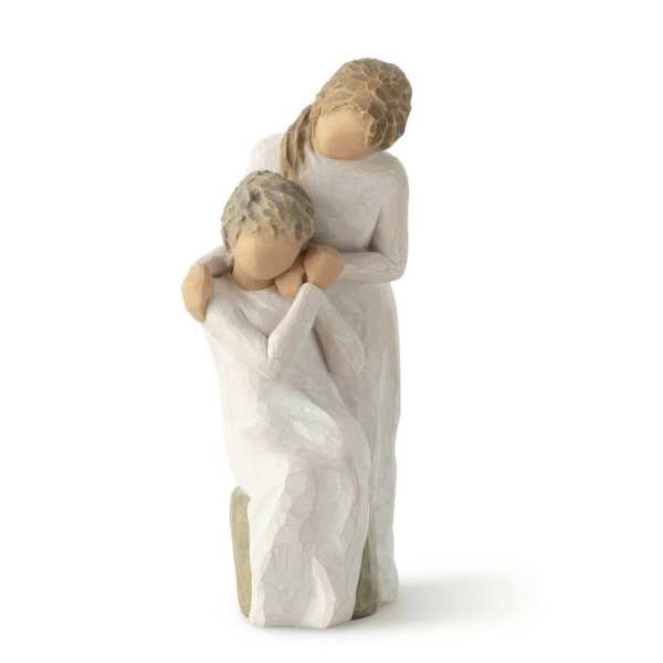 Two carved figurines in white robes embracing