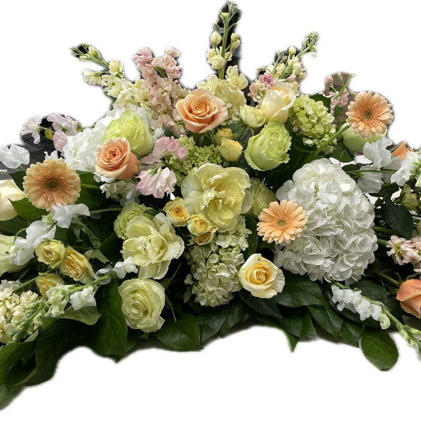 Low floral arrangement with peach, cream, and white blooms