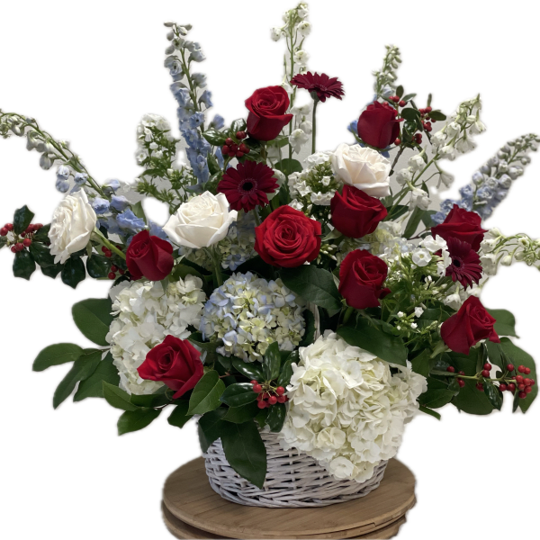 Basket arrangement of red and white roses with blue and white flowers