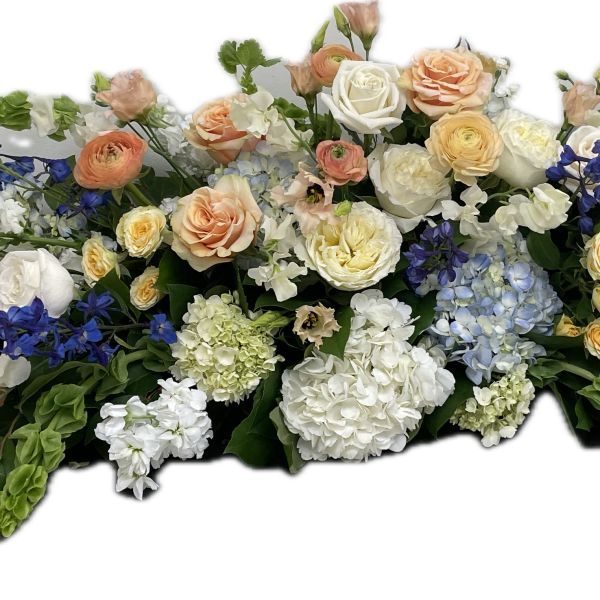 Large floral spray with roses, hydrangeas, and blue flowers