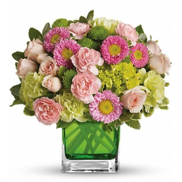 Pink and green mixed bouquet in a green glass vase