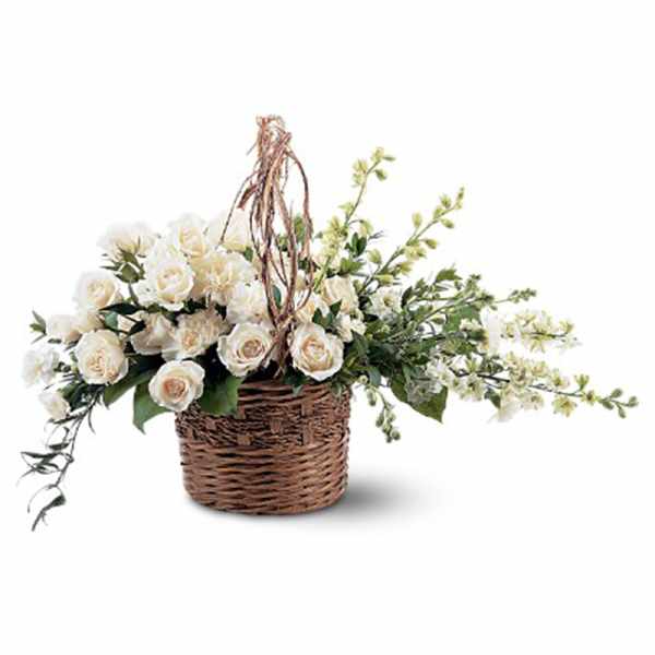 Low basket of white roses and other white flowers arranged in an asymmetrical design