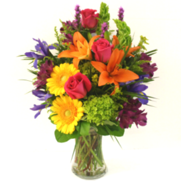 Mixed bouquet of roses, lilies, and daisies in a glass vase