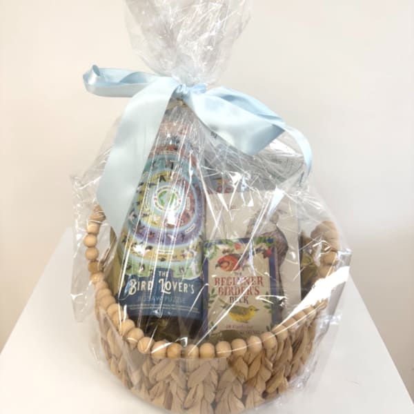 Gift basket with bird-themed books wrapped in clear cellophane and a blue ribbon