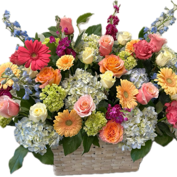 Mixed bouquet in a woven basket with roses, gerbera daisies, and hydrangeas