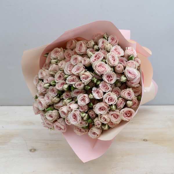 Large bouquet of pale pink spray roses wrapped in soft pink paper