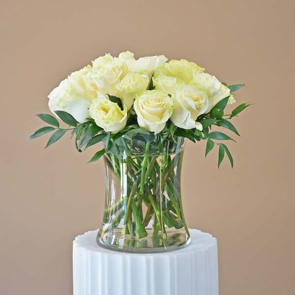 White roses arranged in a clear glass vase