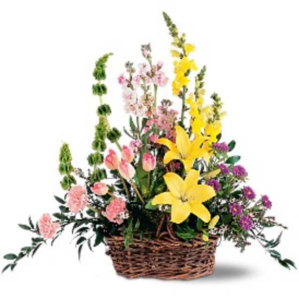 Basket arrangement with yellow lilies, pink flowers, and purple blooms