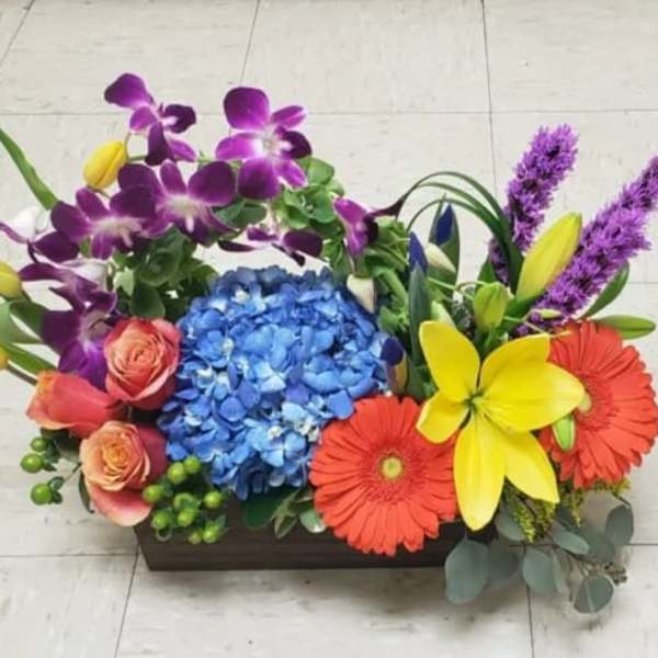 Colorful floral arrangement in a rectangular wooden container