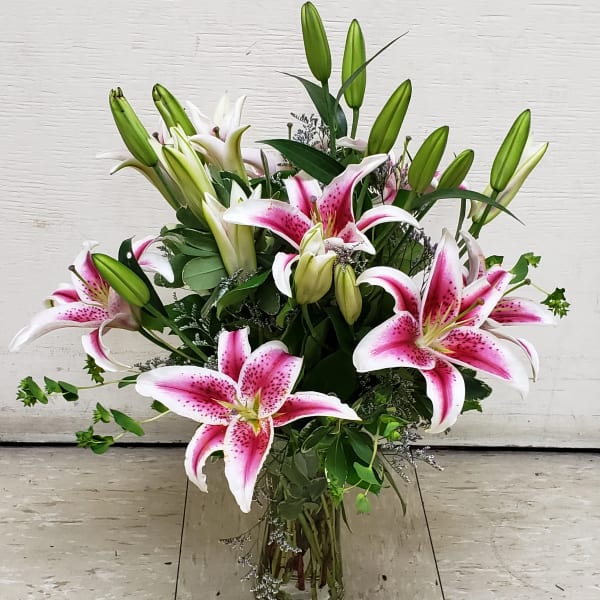 Pink stargazer lilies arranged in a clear glass vase