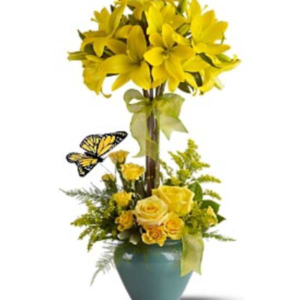 Yellow floral arrangement in a blue vase with a butterfly accent