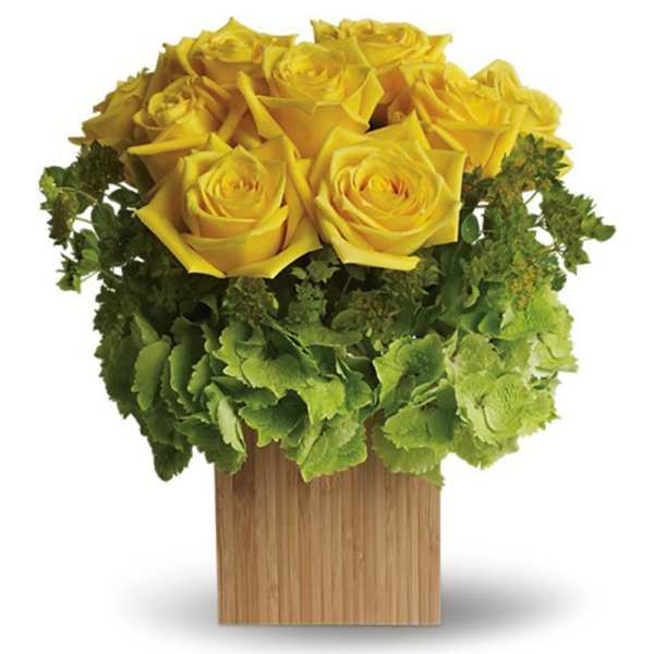 Compact arrangement of yellow roses and green hydrangeas in a square wood vase
