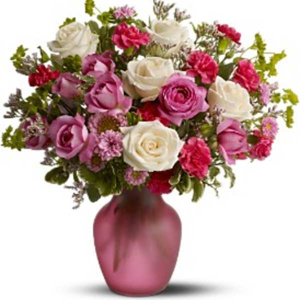 Pink and white roses arranged in a pink vase