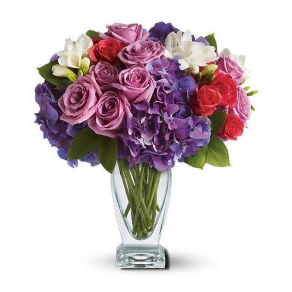Bouquet of purple, pink, red, and white flowers in a clear glass vase
