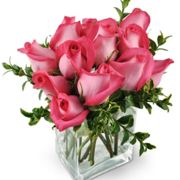 Pink roses arranged in a clear glass vase