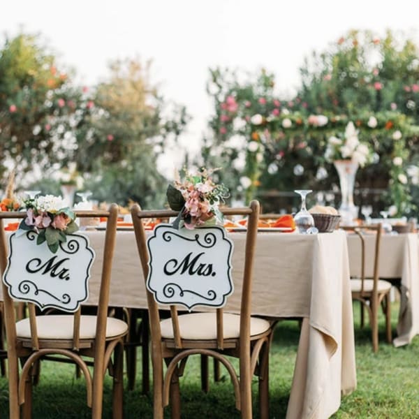 Wedding reception table with floral chair signs reading Mr. and Mrs.