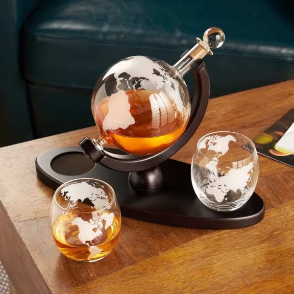 Glass globe decanter with two matching whiskey glasses on a tray