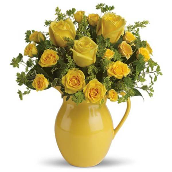 Yellow roses arranged in a yellow ceramic pitcher vase
