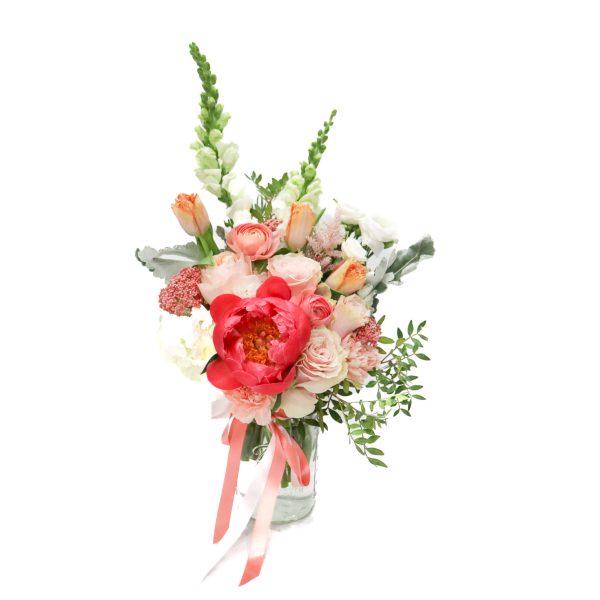 Pink and white bouquet in a glass vase with tall green spikes