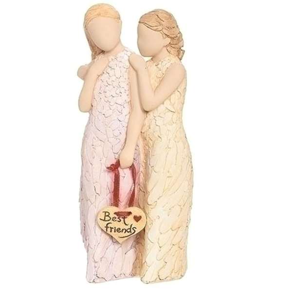 Two angel figurines in pastel dresses holding a "Best friends" heart