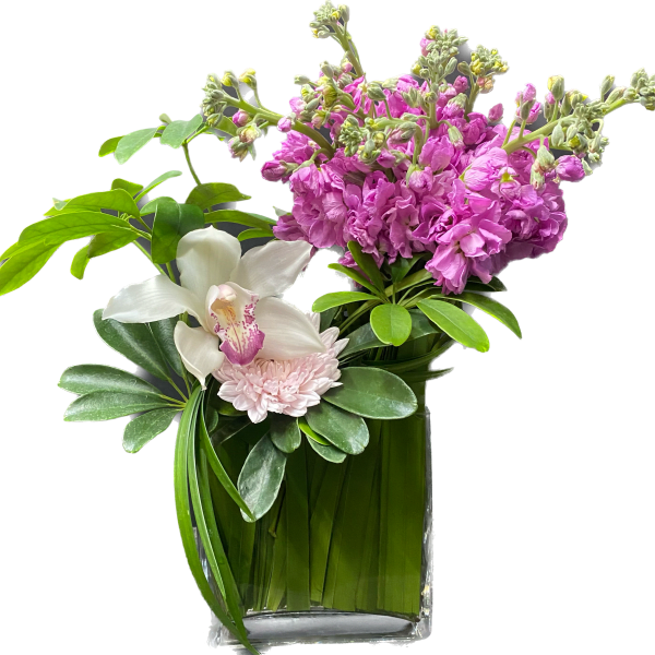 Pink flowers and a white orchid in a clear glass vase